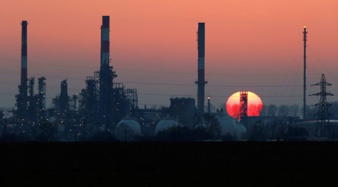Oil edges up on weak dollar; investors weigh rising supplies, demand outlook